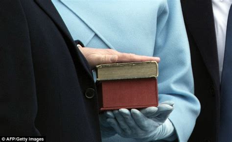 Trump, with his family watching, raises his right hand and places his left hand on the Bible as he t