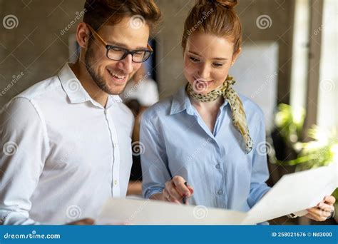 Portrait of Two Young Business People Talking about Documents in Office ...