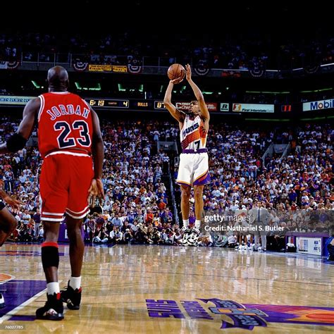 Kevin Johnson of the Phoenix Suns attempts a shot against Michael ...