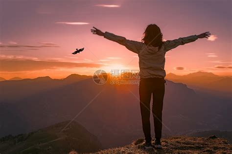 插图泰日落时山顶上的女人看着老鹰张开双臂高清图片下载-正版图片307634337-摄图网