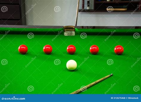 A Green Pool Table with Eight Balls and a Cue in the Middle Stock Photo ...