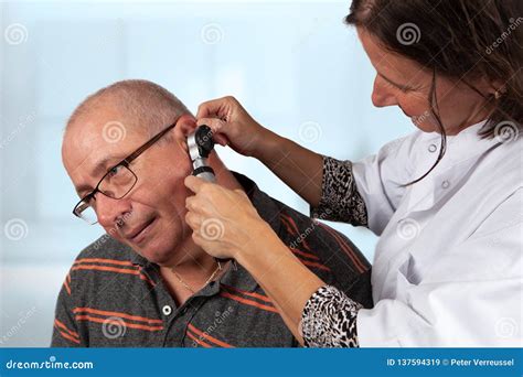 Doctor Examines Ears with Otoscope Stock Image - Image of provider, patient: 137594319