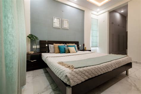 Compact Bedroom Design With A Grey Headboard Wall With Framed Art ...