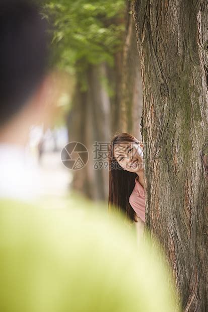 公园里躲在树后的年轻女性高清图片下载-正版图片502094134-摄图网