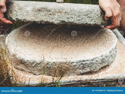 El Molino De Mano Antiguo De La Piedra Del Quern Con El Grano El Hombre ...