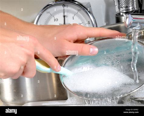 WOMAN WASHING POTS AND PANS Stock Photo - Alamy
