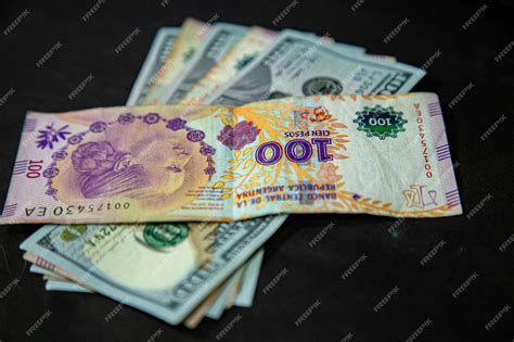 Premium Photo | Argentine peso and dollars on a table with pc on background