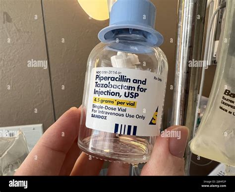 Person's hand holding a vial of intravenous (IV) antibiotics from ...