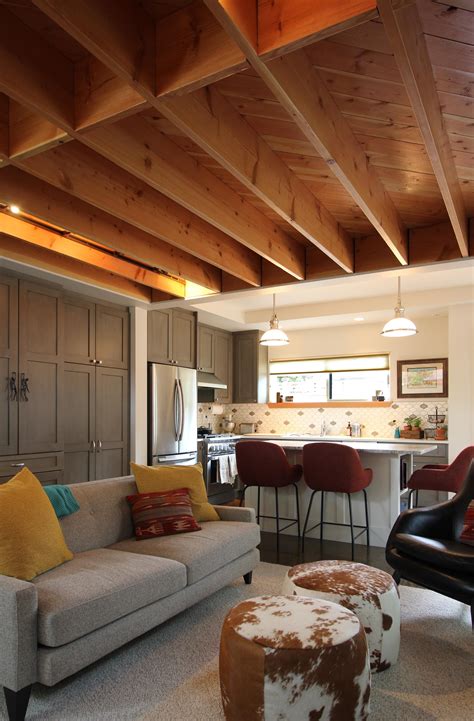 A living room for a backyard cottage featuring exposed joist ceilings ...