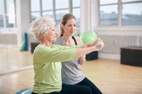 Senior Woman Training In The Gym With A Personal Trainer Stock Photo ...