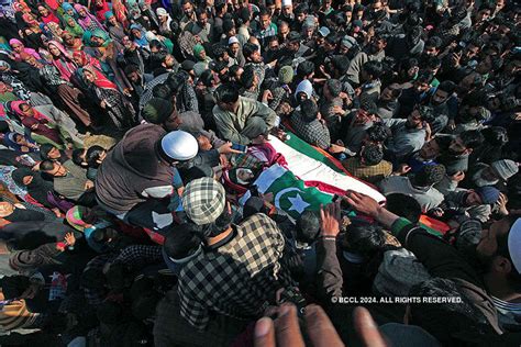 Villagers watch the funeral procession of Hizbul Mujahideen commander ...