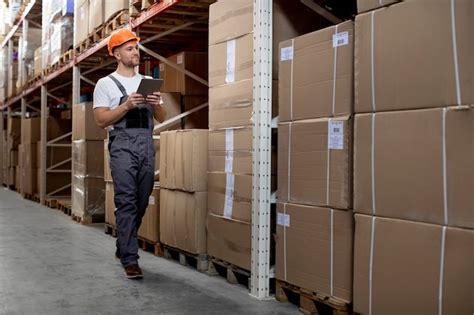 Full shot man working in logistic warehouse | Free Photo