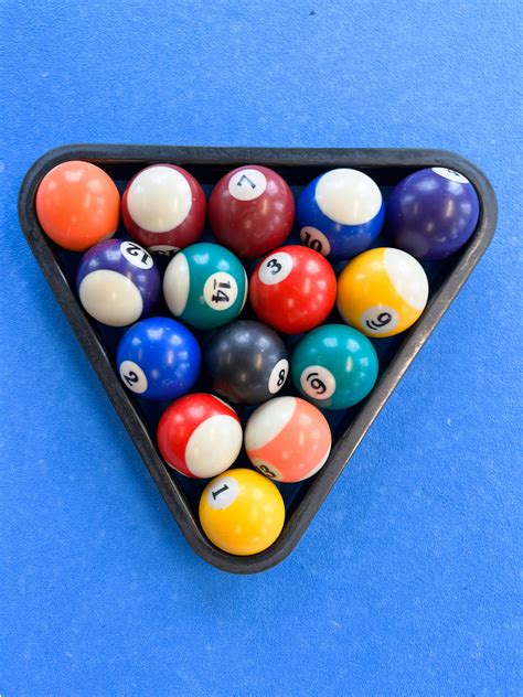 A triangle shaped pool table filled with pool balls photo – Free ...