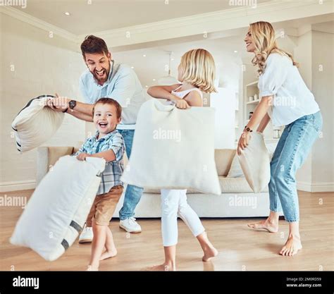 Excited family having a pillow fight. Caucasian family playing with ...