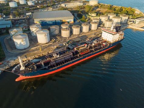 Aerial view of chemical industry storage tank and tanker ship entering ...