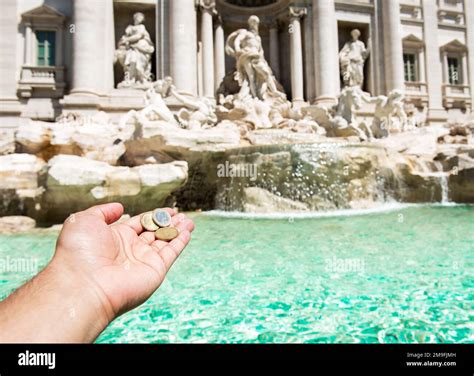 Man is throwing coin at Trevi Fountain for good luck. A man hand ...