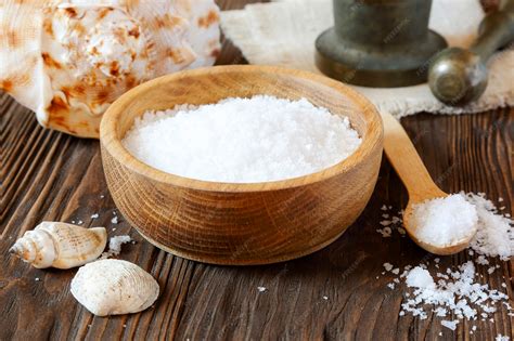Sea salt in a wooden bowl on the table | Premium Photo