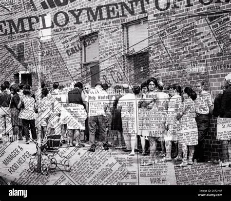 1960s GROUP PEOPLE STANDING IN LINE ALONG STREET WITH NEWSPAPER ADS OF EMPLOYMENT SUPERIMPOSED ...