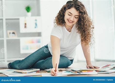 The Woman Sitting on the Table and Drawing on a Paper. Stock Photo ...