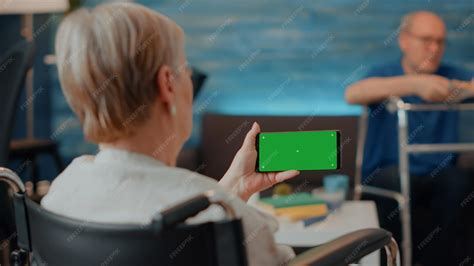 Retraité handicapé utilisant un écran vert horizontal sur téléphone ...