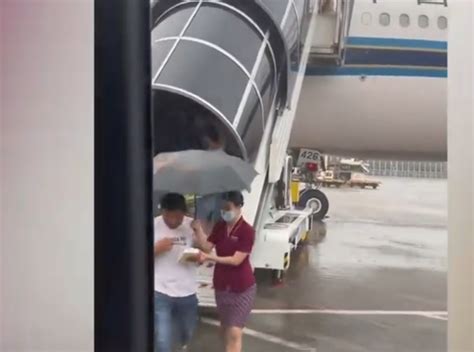 空姐不顾淋湿为乘客撑伞避雨，南航回应：并非固定服务，会有相应的表扬机制_腾讯新闻