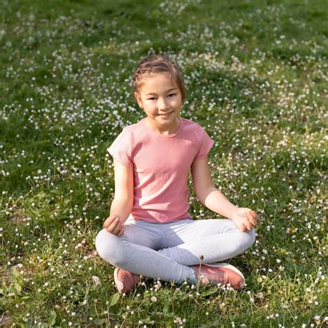 Full shot girl sitting on grass | Free Photo