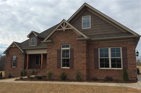 Upgrade Your Curb Appeal: Stunning Brick House with Brown Shutters!