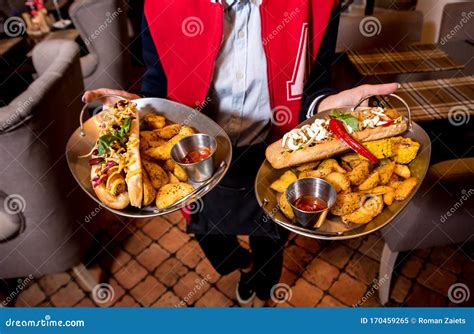 Waiter, Carrying Two Plates with a Big Hot Dogs and French Fries ...