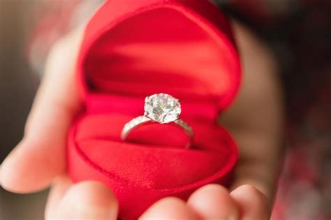 Hands holding diamond ring in jewelry box | Premium Photo