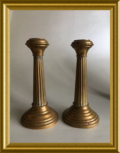 Two small antique brass candle holders