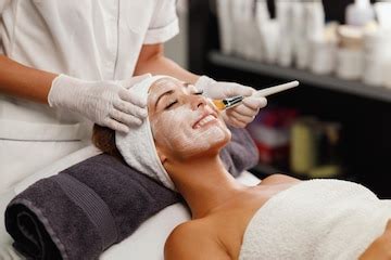 Shot of a beautiful young woman getting a facial mask treatment at the ...