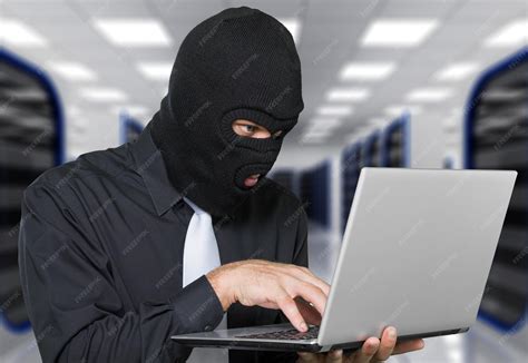 Premium Photo | Burglar wearing black mask stealing identity using computer