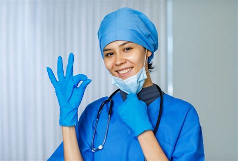 Happy pretty female freedom doctor in blue hospital suit with ...