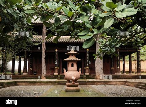 Photo of an elaborate Chinese temple with hedges in front.