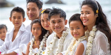 Thai family in traditional white clothing with floral garlands at beach ...