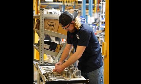 An individual working on a metal assembly line or workbench, surrounded ...
