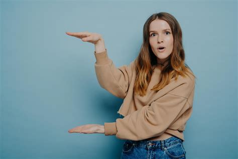 Surprised female showing big large size with hands 13001920 Stock Photo at Vecteezy