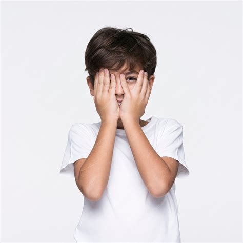 Młody chłopak obejmujących twarz rękami | Zdjęcie Premium