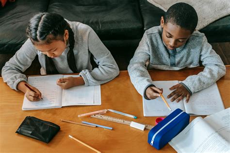 Focused children doing homework at table · Free Stock Photo