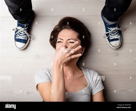 Woman holding her nose against the smell of feet in sneakers standing on either side of her head ... - what is the smell of feet