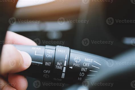 close up hand adjusting rain windscreen wiper knob control stick switch speed of screen front ...