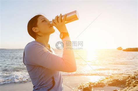 女人海滩上喝水轻女子海滩上锻炼后喝水高清图片下载-正版图片300361158-摄图网