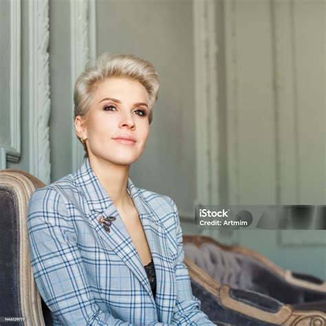 Perfect Blonde Short Haired Woman In Blue Suit Is Looking To The Camera ...