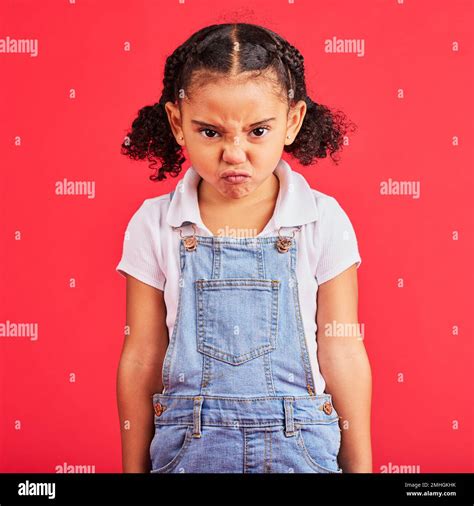 Child, portrait or angry face on isolated red background in emoji tantrum, behavior or stubborn ...