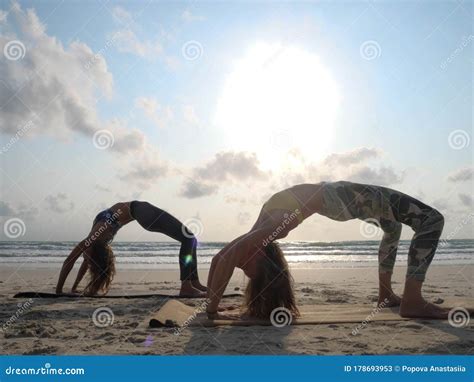 Two Girl Practice Wheel Yoga Pose at Seaside at Sunset Stock Image ...