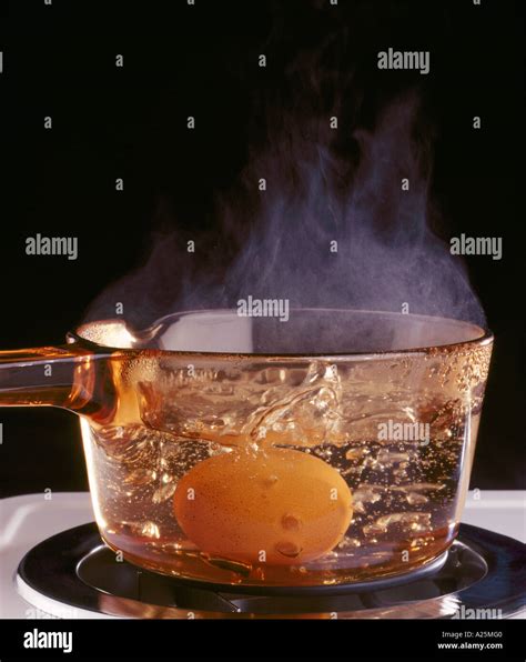 Boiling an egg in a pyrex saucepan Stock Photo - Alamy