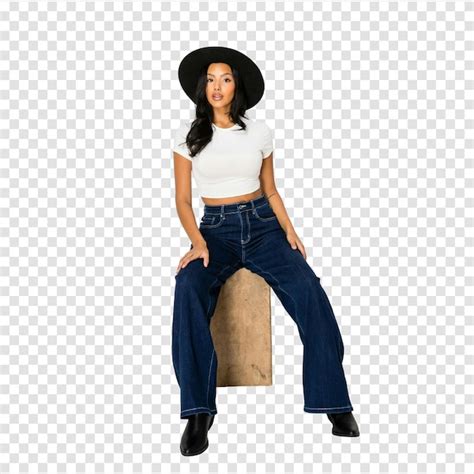 Stylish woman in wide-leg jeans and hat posing on a block | Premium PSD
