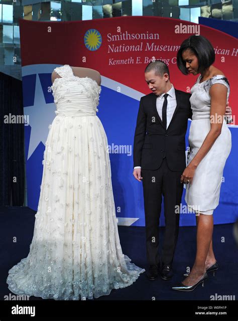 First Lady Michelle Obama and fashion designer Jason Wu look at her inaugural gown at an event ...