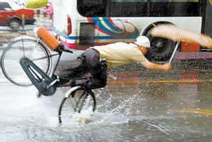 记者抓拍骑车人暴风雨中遇水坑摔倒遭网民痛骂_新闻中心_新浪网