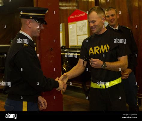 Capt. Austin Hatch, Caisson platoon leader, presents Staff Sgt. Steven Taylor with custom-made ...
